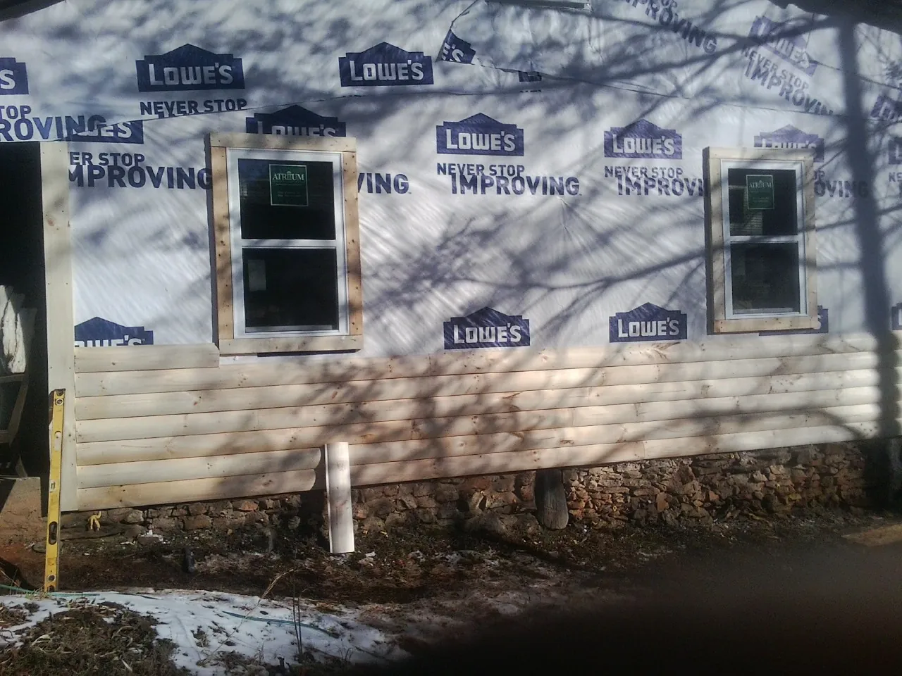 House wrap and new log siding going up on an exterior wall in Flemington