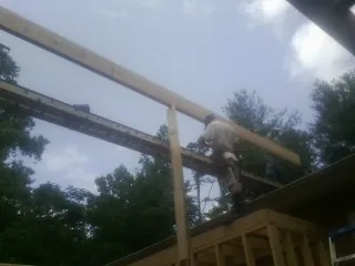Carpenter setting a ridge beam over a new addition frame — Ice Dam Removal by Roofing Brothers in Flemington